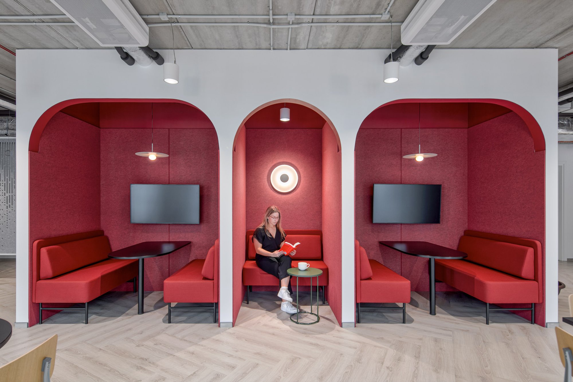 woman reading a book in a nook in an office space