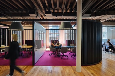 Office fit out of two people collaborating in an open touchdown space. 