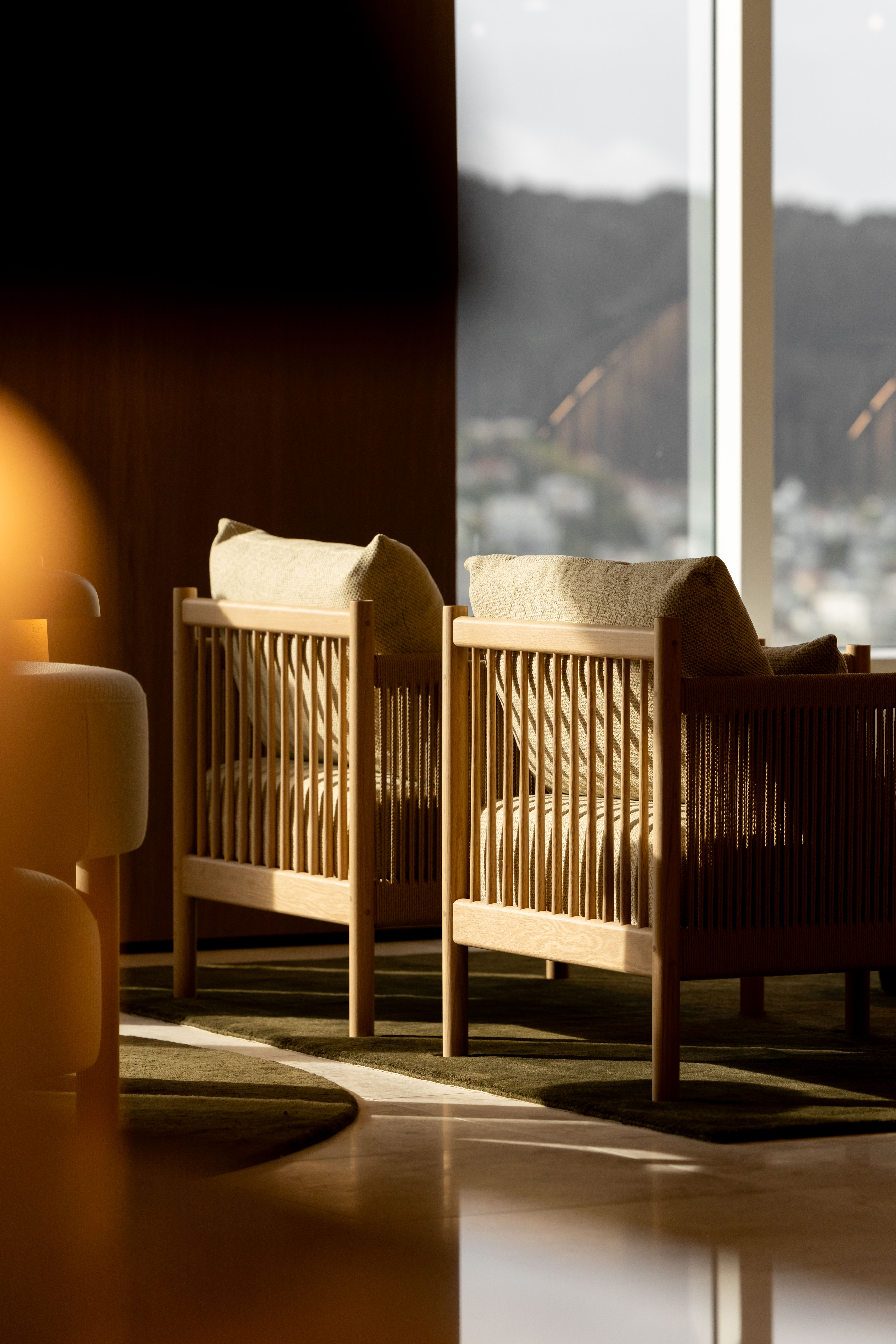 Detail image of waiting area chairs with sunlight streaming in at Russell McVeagh's Wellington office