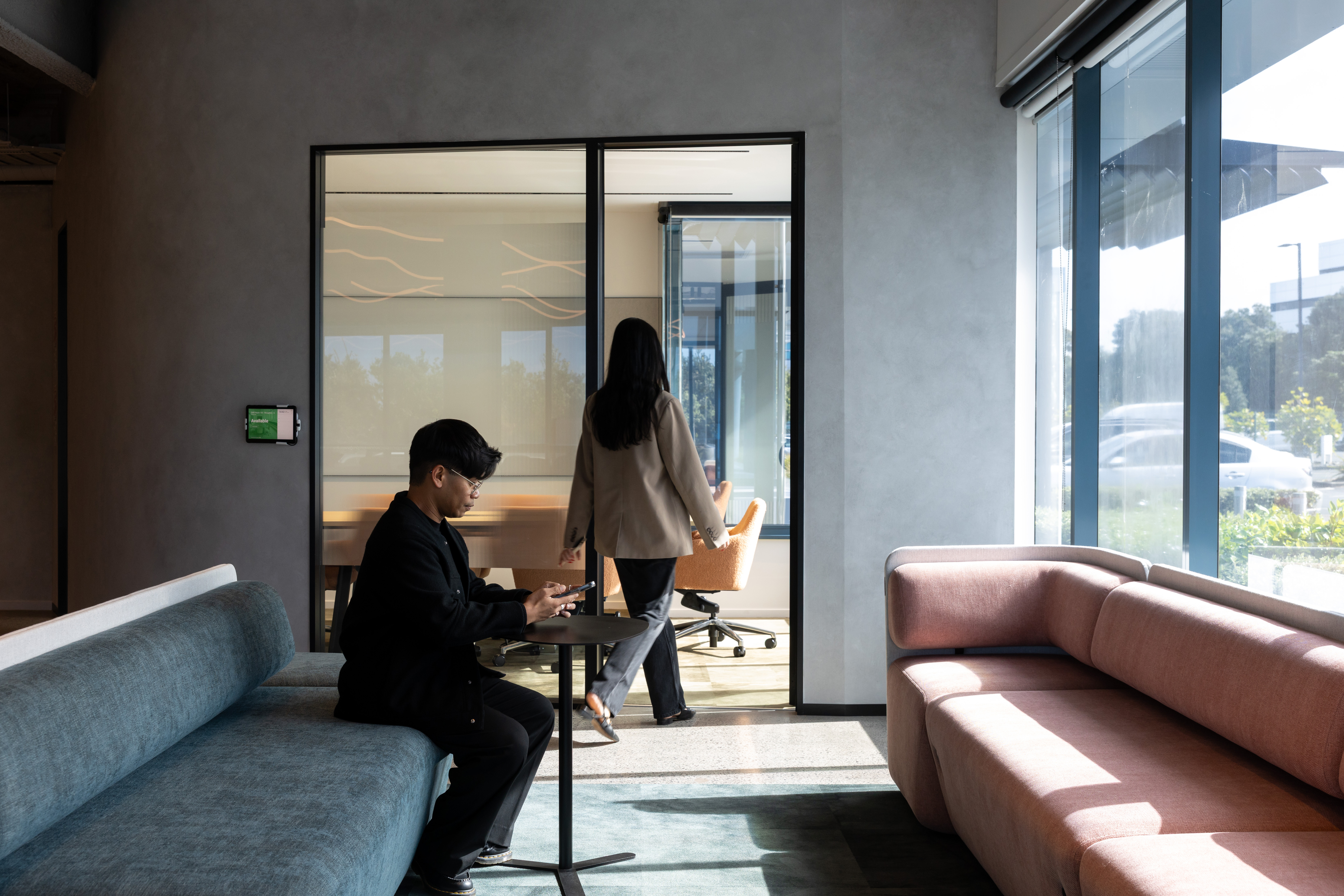 Meeting room with large glass windows, allowing natural light to filter through Samsung's office interior