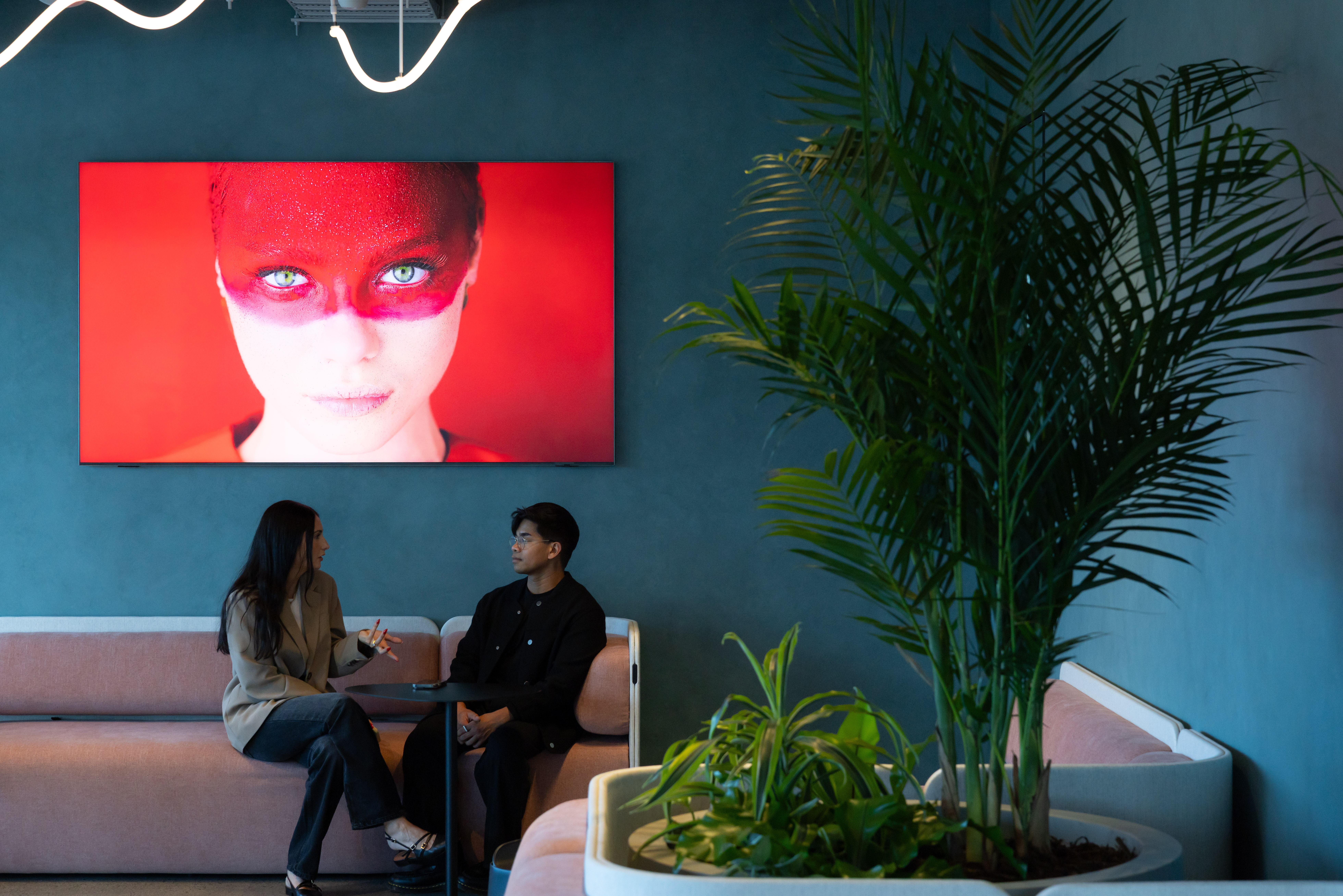 Two people sat at Samsung's Auckland office with digital signage