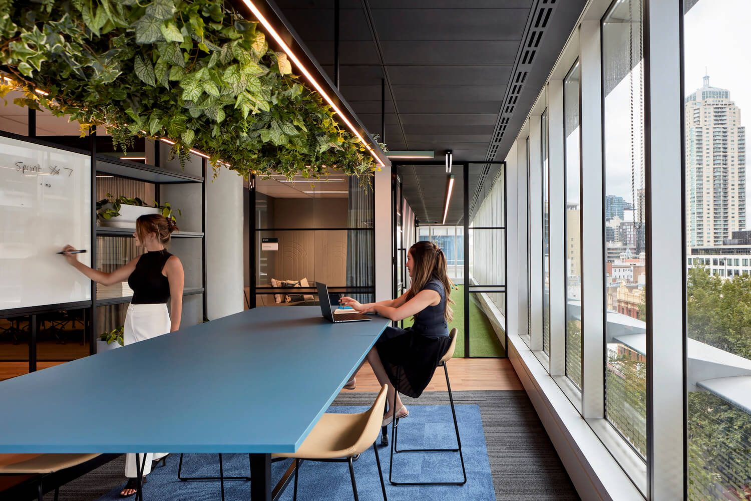 Two women collaborating on a whiteboard Global software company Sydney
