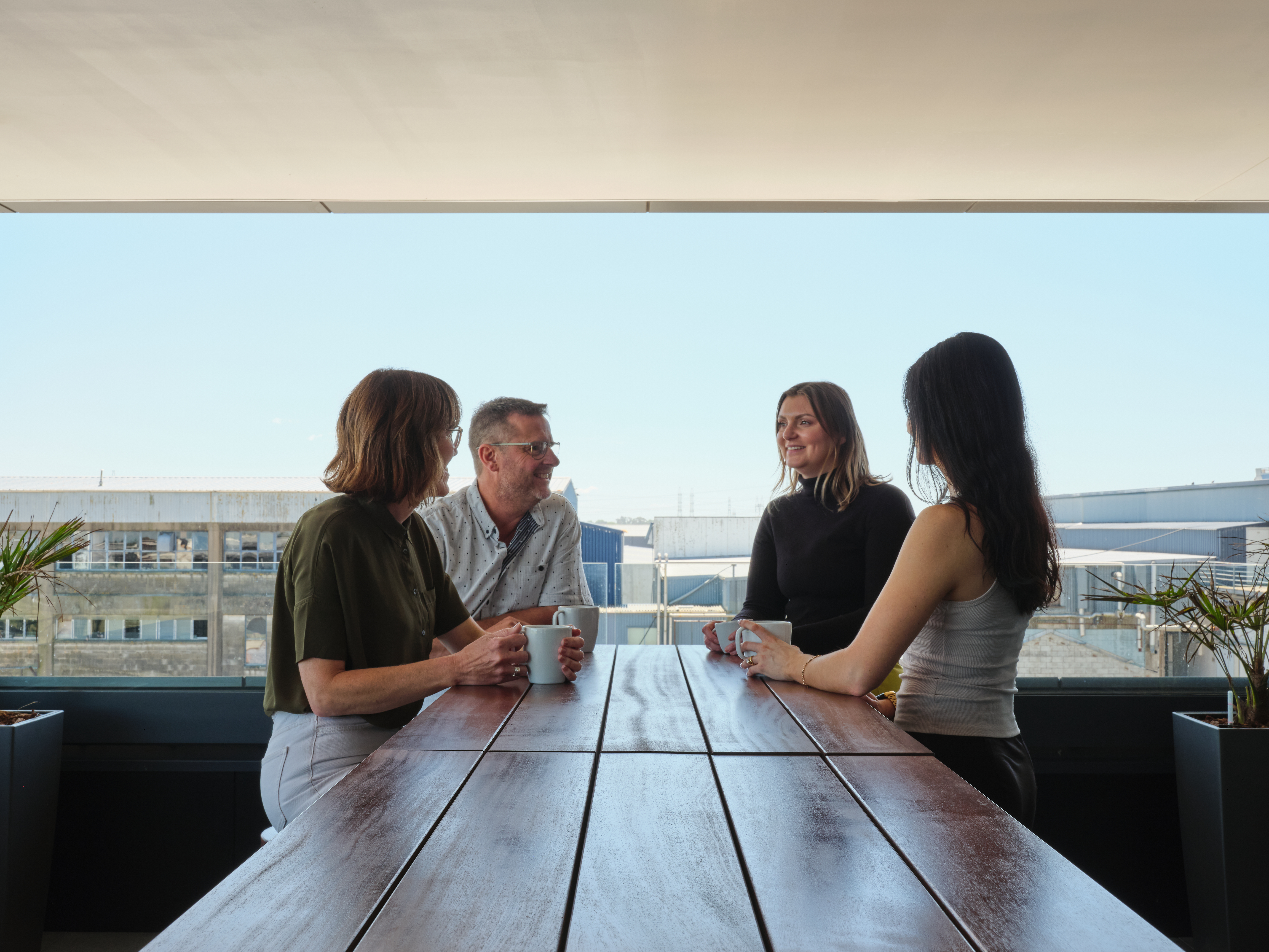 Employees gather around outdoor bar leaner in the afternoon