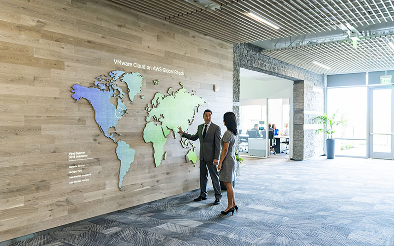 Man and woman interacting with digital map on a wall